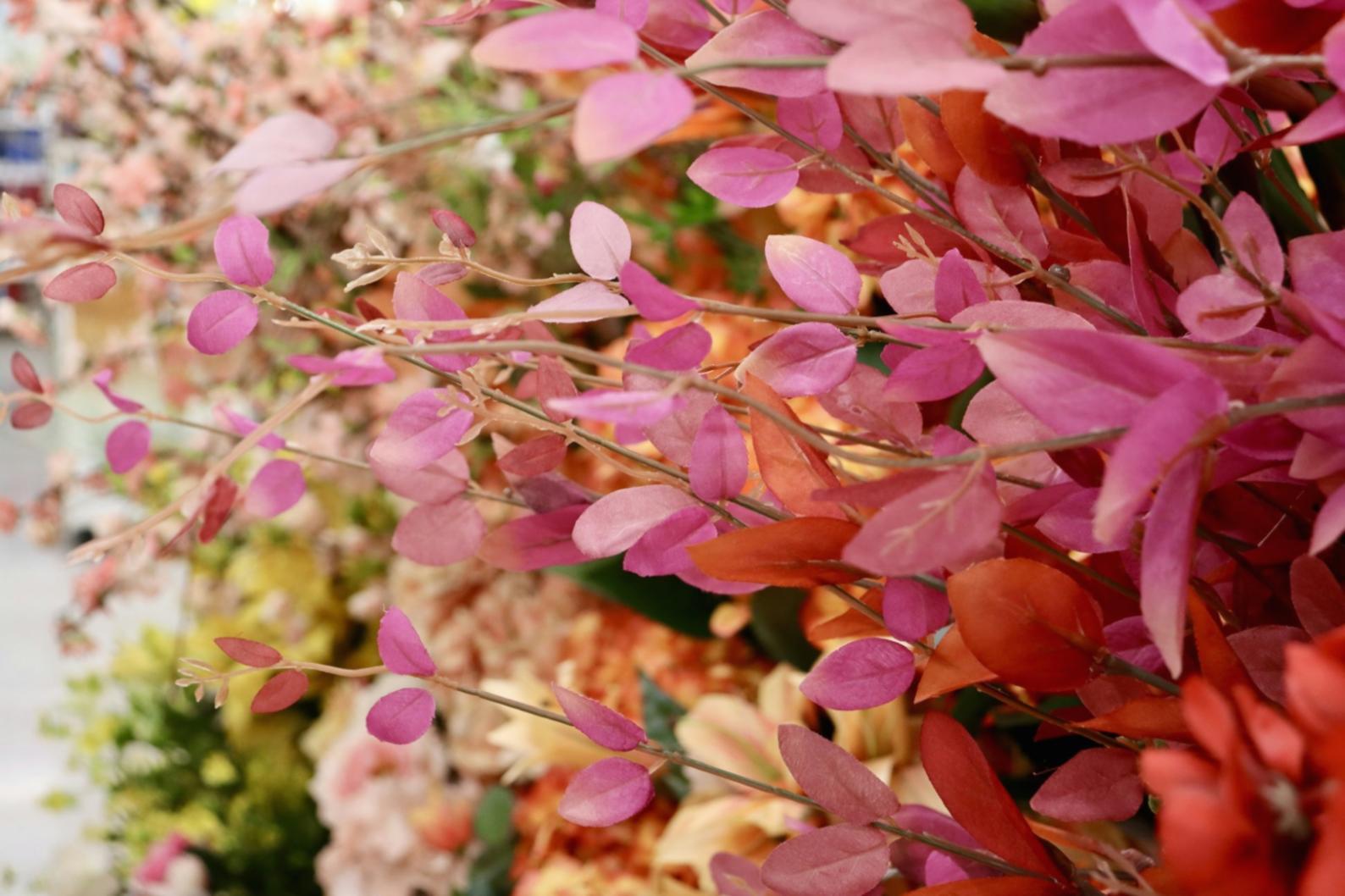 Student arranging sustainable flowers in a bright, natural workshop space